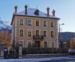 una grande casa con una recinzione davanti di Le cocon de la Pare- Superbe T3 plein centre a Barcelonnette