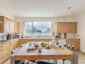 a kitchen with a large wooden table with chairs at 4 Bed in The Cairngorms 46162 in Tomintoul