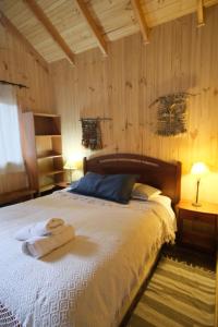 ein Schlafzimmer mit einem Bett mit zwei Handtüchern darauf in der Unterkunft Casa de Noah Bed & Breakfast in Pucón
