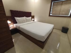 a bedroom with a large white bed in a room at Hotel New Peninsula Suite - Near Masjid Bandar and CST Station - South Mumbai in Mumbai