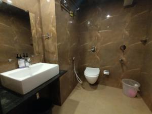 a bathroom with a sink and a toilet at Hotel New Peninsula Suite - Near Masjid Bandar and CST Station - South Mumbai in Mumbai