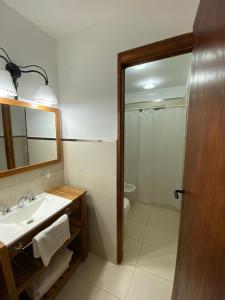 ein Badezimmer mit einem Waschbecken, einem WC und einem Spiegel in der Unterkunft Bosques del Este in Costa del Este