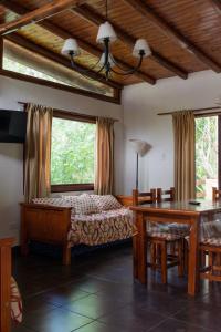 1 dormitorio con cama, mesa y ventanas en Bosques del Este en Costa del Este