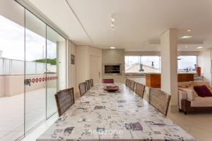 a dining room with a long table and chairs at Apto luxuoso a 450m da praia em Floripa ADI0302 in Florianópolis