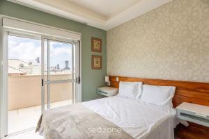 een slaapkamer met een bed en een groot raam bij Apto 450m da Praia dos Ingleses Floripa-SC ADI0302 in Florianópolis