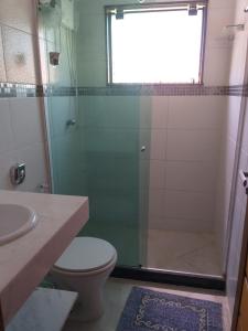 a bathroom with a shower with a toilet and a sink at Suite Grande Rio in Duque de Caxias