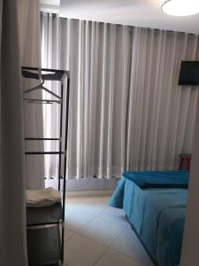 ein Schlafzimmer mit einer Leiter, einem Bett und Vorhängen in der Unterkunft Suite Grande Rio in Duque de Caxias