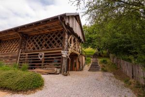 a wooden barn with a staircase leading up to it at Hay barn unique experience Visole in Slovenska Bistrica