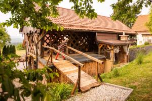 una mujer parada en un porche de una casa de madera en Hay barn unique experience Visole, en Slovenska Bistrica