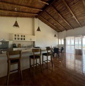 uma cozinha e sala de jantar com cadeiras e uma mesa em Vichayito, Órganos, Casa Serendipity em Vichayito