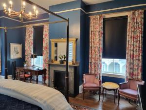 sypialnia z niebieskimi ścianami, łóżkiem i kominkiem w obiekcie Thomas Weihs Haus w mieście Savannah