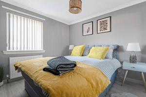 um quarto com uma cama amarela e azul em Stylish 2-Bed House Private Driveway em Glasgow