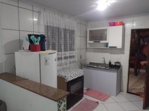 a small kitchen with a refrigerator and a sink at Mar de araçatiba (kitnet) in Angra dos Reis