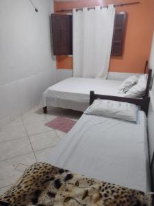 a room with two beds and a cheetah blanket at Mar de araçatiba (kitnet) in Angra dos Reis