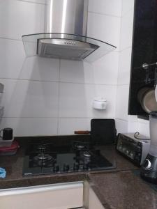 uma cozinha com uma placa de fogão e forno. em Suite Grande Rio em Duque de Caxias
