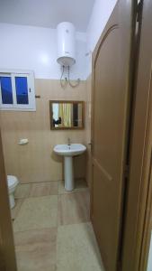 uma casa de banho com um lavatório e um WC em Résidence abdou diouf em Dakar