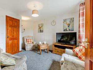 a living room with a tv and a couch and a chair at 2 Bed in Bude 51764 in Pyworthy
