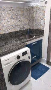 a washing machine in a kitchen with a sink at Lindo Ap-Centro de Guarapari(Sem Compartilhamento) in Guarapari
