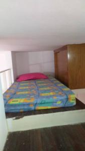 a small bed in a room with a wooden cabinet at Lindo Ap-Centro de Guarapari(Sem Compartilhamento) in Guarapari