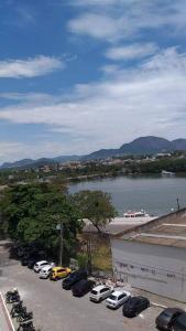 a parking lot with cars parked next to a river at Lindo Ap-Centro de Guarapari(Sem Compartilhamento) in Guarapari