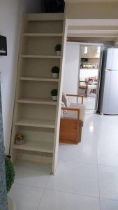 a staircase in a room with a kitchen and a refrigerator at Lindo Ap-Centro de Guarapari(Sem Compartilhamento) in Guarapari