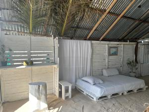 a bedroom with a bed and a wooden wall at Punta Arena EcoHostal Coco in Playa Punta Arena