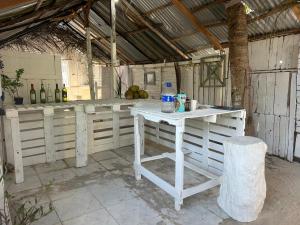 a kitchen with white counters and bottles of wine at Punta Arena EcoHostal Coco in Playa Punta Arena