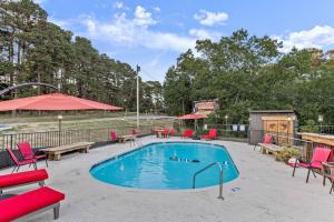 - une piscine avec des chaises rouges et une table de pique-nique dans l'établissement Stonegate Lodge King Bed, WIFI, 50in Roku TV, Salt Water Pool Room #107, à Eureka Springs