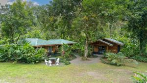 uma casa no meio de um quintal em Eden Organic Farm & Bungalows em La Fortuna