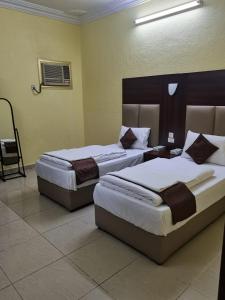 two beds in a hotel room with two beds sidx sidx sidx at العييري للشقق المخدومة المدينة 3 in Al Madinah +10 photos