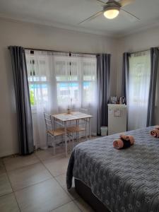 a bedroom with a bed and a table and a dining room at GUESTHOUSE on REGENT Bed & Breakfast in Caloundra