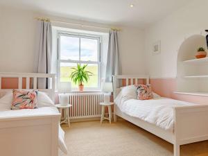 a bedroom with two beds and a window at 4 Bed in Looe 82662 in Lanreath
