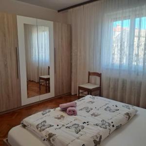 een slaapkamer met een bed, een spiegel en een stoel bij Apartment Parenzana Bibali 65 A 52460-Buje in Buje