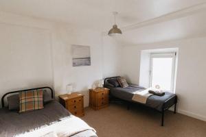 1 dormitorio con 2 camas y ventana en SUMMER VIEW - Escape to our Cosy Cottage with Log Burner en Drigg