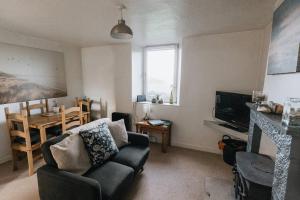 a living room with a couch and a table at SUMMER VIEW - Escape to our Cosy Cottage with Log Burner in Drigg