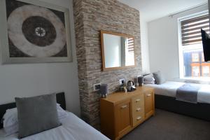a bedroom with two beds and a brick wall at Hotel 33 in Blackpool