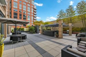 an outdoor patio with tables and umbrellas at Reston 1br w bbq grills close to shopping WDC-837 in Reston