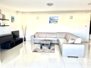 sala de estar con sofá y TV en Delux 4 Stars Apartment Ariadne - 1 Min from Beach, en Soline