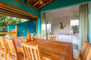 uma sala de jantar com uma mesa de madeira e cadeiras em Casa Bambolê em Ilhabela em Ilhabela