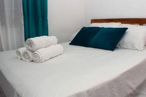 Una cama blanca con tres toallas enrolladas. en Salamanca Loft, 