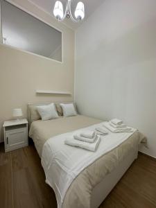 um quarto branco com 2 camas e um espelho em Apulia White House 59 em Bari