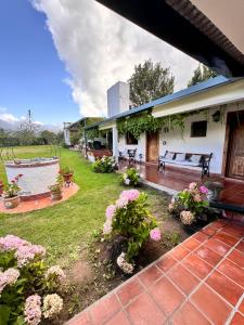 un patio con panchina e fiori in un cortile di Descanso Perfecto en Tafí del Valle a Tafí del Valle