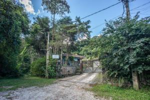 a house in the middle of a dirt road at Chalé Le Refuge in Teresópolis