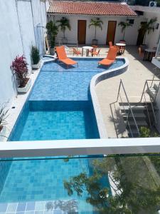 twee foto's van een zwembad met stoelen en tafels bij Serra Plaza Premium in Serrinha