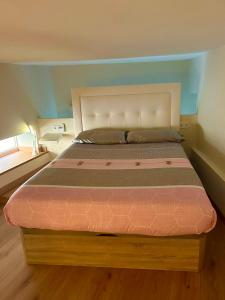 Schlafzimmer mit einem großen Bett mit einem weißen Kopfteil in der Unterkunft MADRID CENTRO II in Madrid