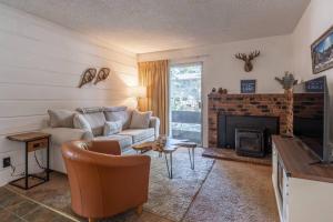 een woonkamer met een bank en een open haard bij Cozy Cabin-Style Condo in Central Location in Mammoth Lakes