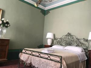 - une chambre avec un lit avec un cadre métallique dans l'établissement Palazzo Montesi, à Mombaroccio