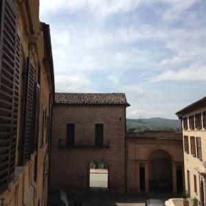 un callejón con un edificio y un arco en la distancia en Palazzo Montesi, en Mombaroccio