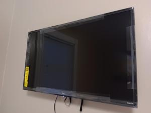 TV de pantalla plana colgada en la pared en The Top-Floor at Centerdale Village Room B* Private Room, en North Providence