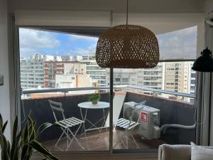 Habitación con vistas a un balcón con mesa y sillas. en Muy cómodo y trendy, en Montevideo